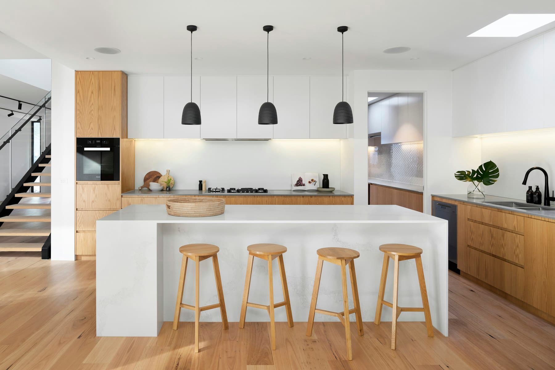Warm stone and timber Melbourne kitchen with nickel fittings